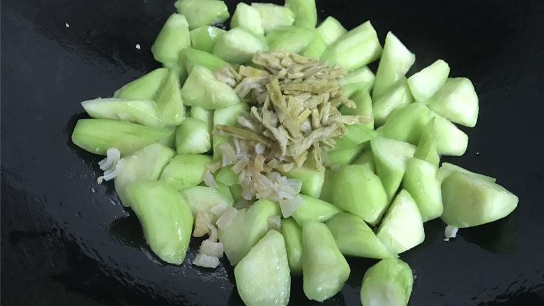 鲜贝扁尖笋丝瓜,炒至丝瓜变色后加入鲜贝丝和扁尖笋段。