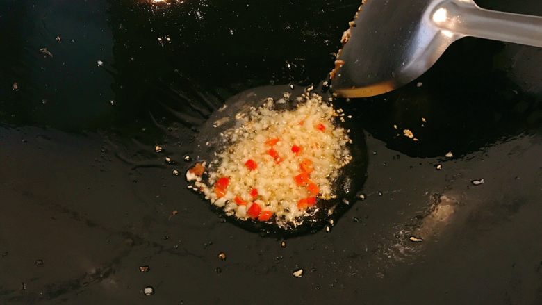 香辣杏鲍菇丁,锅中余油，放入白芝麻、小辣椒、蒜碎。炒香。