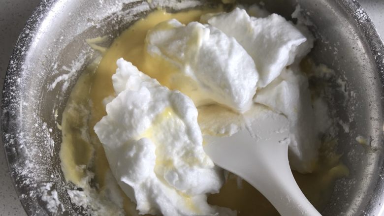 巧克力甘纳许淋面蛋糕（6寸）,把三分之一的蛋白霜倒入蛋黄糊中翻拌均匀。