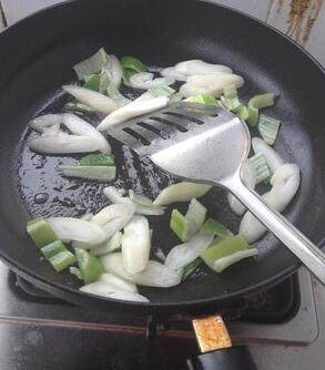 家常菜谱--葱烧豆腐,锅底油不要倒出，将葱切段放入锅中煸炒。