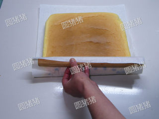 葡萄干蛋卷,重新取一张干净油纸，垫在有葡萄干的一面。一端放一支擀面杖。