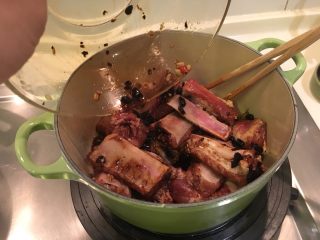 铸铁锅版之䜴汁排骨,将拌好调味料的肋排放进锅里