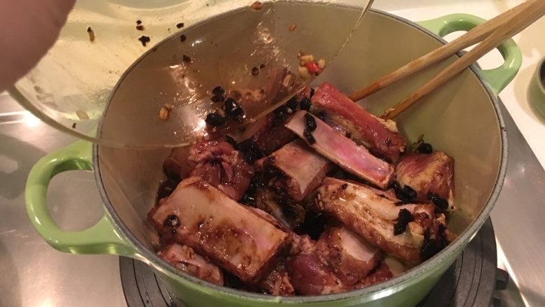 铸铁锅版之䜴汁排骨,将拌好调味料的肋排放进锅里
