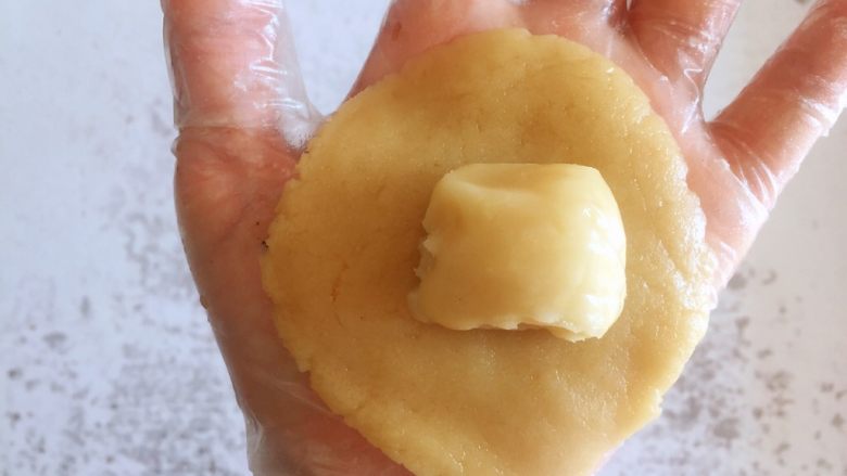 传统双酥果仁月饼（木糖醇糖浆）,取一个油酥面团放在油皮面饼中间，用油皮把油酥紧紧包住