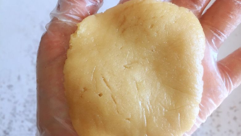 传统双酥果仁月饼（木糖醇糖浆）,取一个油皮部分的面团在手中按扁，面团特别软，在掌心轻按即可