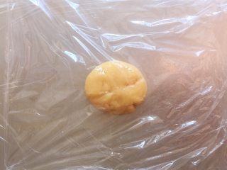 传统双酥果仁月饼（木糖醇糖浆）,取一个包好的面团放在操作台上，面团上下层各铺一层保鲜膜，这样方便操作