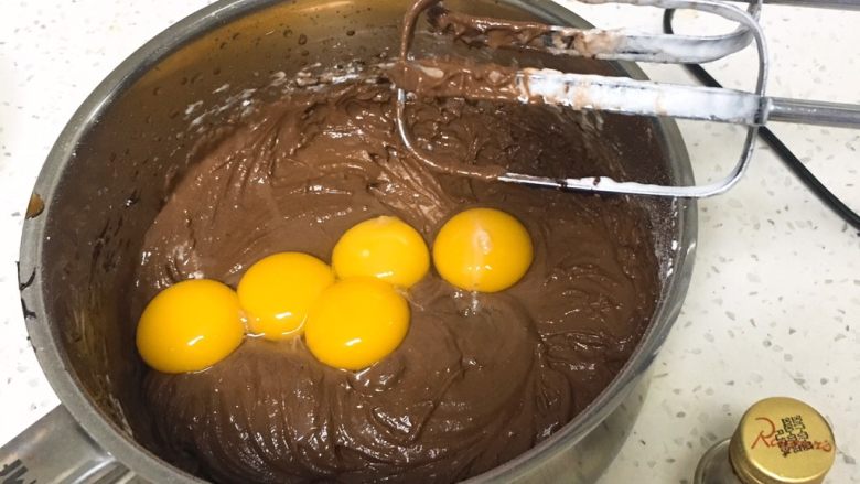 可可巧克力蛋糕,加入蛋黄和香草精，继续搅打均匀。