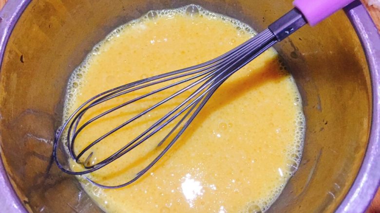 香葱芝麻肉松蛋糕卷,蛋黄里加入玉米油、牛奶，用手抽搅拌均匀