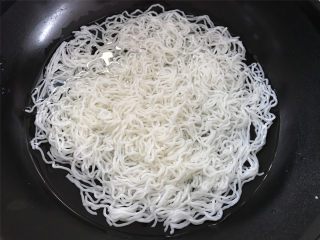 家常炒米粉,2块米粉放锅中冷水泡开。