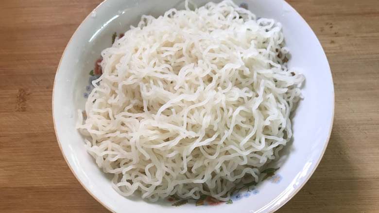 家常炒米粉,用筷子滑散后捞出沥干水份。