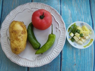 柿子炒土豆片,先准备一个土豆，一个柿子和两个尖椒，然后切好葱姜蒜。