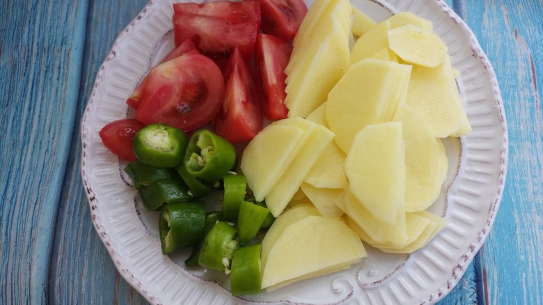 柿子炒土豆片,把土豆切成片，柿子切成块。尖椒切成椒圈。