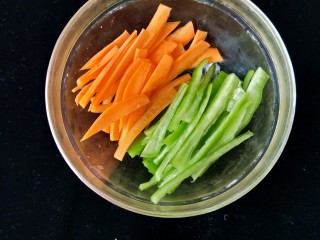 百吃不厌~酸辣土豆丝,胡萝卜切丝，尖椒从中间切开，去掉籽和白膜，然后也切成丝。