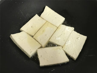  八宝酱豆腐,7成热时把沾上面粉的豆腐放入锅中。