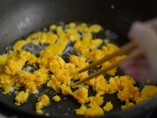 赛螃蟹炒饭,锅中再倒入少许油，倒入蛋黄液，待蛋液凝固后用筷子划散