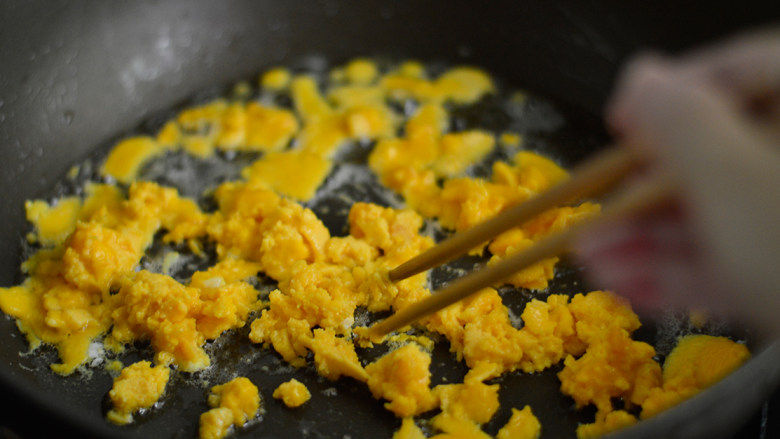 赛螃蟹炒饭,锅中再倒入少许油，倒入蛋黄液，待蛋液凝固后用筷子划散