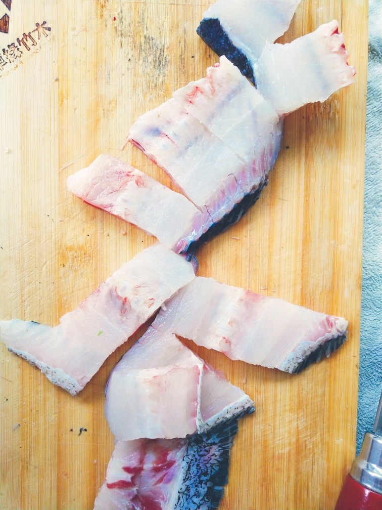 酸菜鱼,鱼骨切块。鱼头切开两半