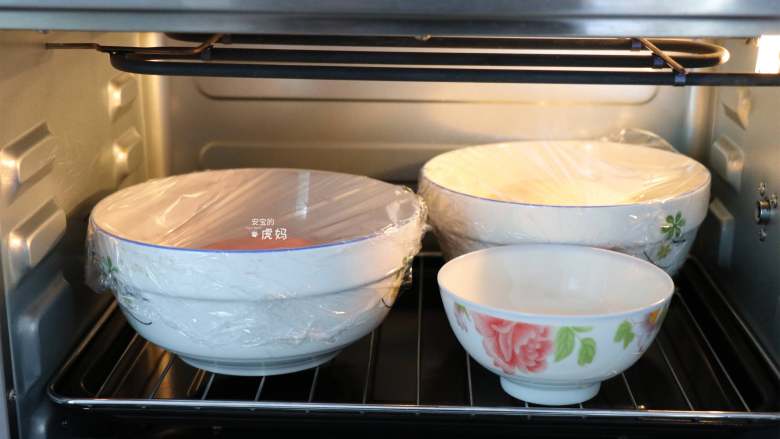 双色馒头,包上保鲜膜，放进烤箱，开启发酵功能，也可以直接放在潮湿温暖的地方发酵；