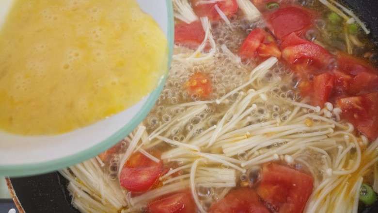西红柿金针菇鸡蛋汤,水再次烧开之后加入鸡蛋液。