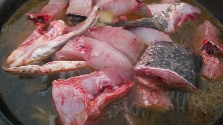 新文美食  家常酸菜鱼,在把鱼块放入锅中，倒入适量水烧开。