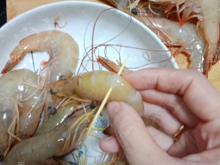 椒盐烤虾,用牙签插在虾的第三节的地方把虾线挑出来。然后剪掉虾须。洗干净沥干水备用