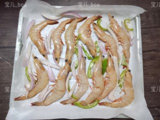 椒盐烤虾,把腌制好的虾和洋葱丝，青椒丝摆在烤盘上