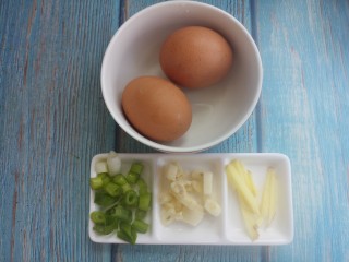煎鸡蛋,先准备两个鸡蛋，再切点葱花，蒜瓣，还有姜丝。