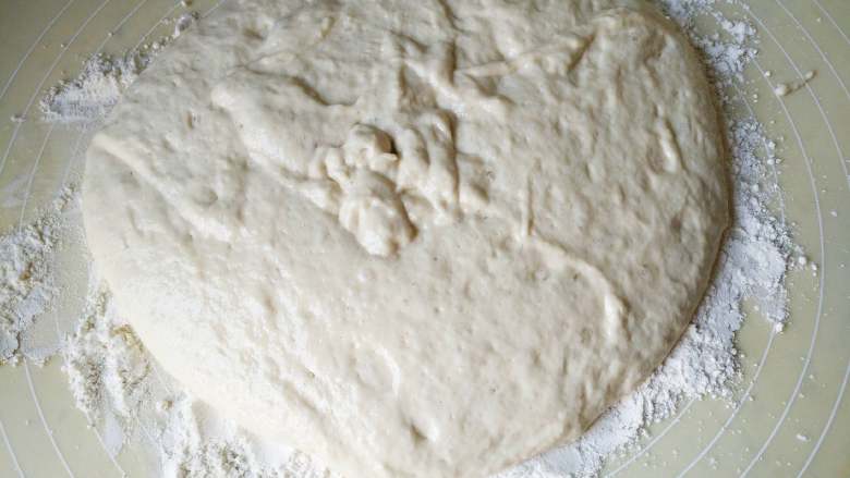 香酥芝麻烧饼,在台面上放多一些面粉，将面糊放在面粉中
