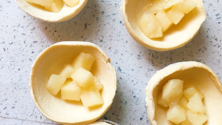 懒人苹果酥,6️⃣ 蛋挞皮中加入适量炒过的苹果丁，不要放太多，不然对折的时候会折不起来的。