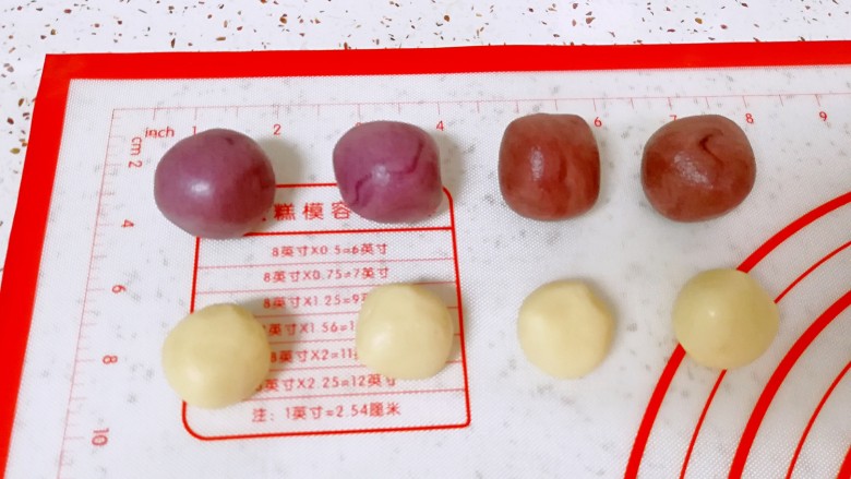 紫薯馅彩色蛋黄酥,把原味的油酥平均分成四份，红色的和紫色的油酥各分成两份。油皮也是平均分成三份，其中一份分成四小份，另外两份各分成两份，分好的油酥和油皮分别搓圆盖上保鲜膜备用。