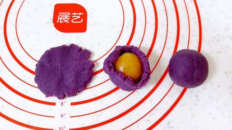 紫薯馅彩色蛋黄酥,分好的紫薯馅压扁，包入咸蛋黄。