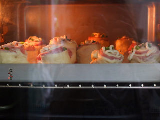 培根芝士面包卷,放入预热好的烤箱内，以180度，上下火烘烤25分钟即可。