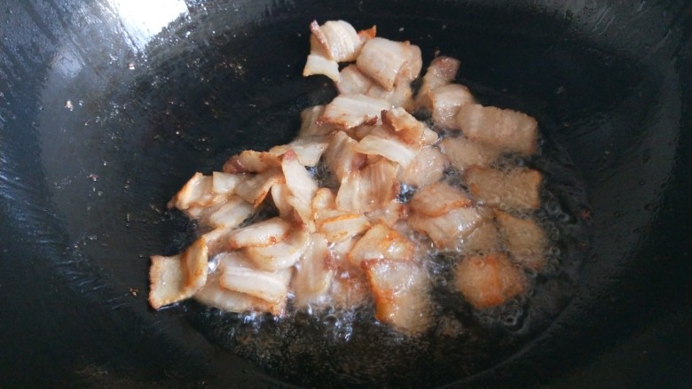 新文美食  五花肉炒蛇豆,锅中倒入适量油烧热，放入五花肉煸炒出油。
