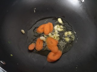 西兰花炒蘑菇,锅里放油
倒入蒜末、胡萝卜炒香