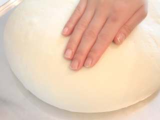 日式盐卷面包,把面团整圆，放入烤盘中，稍拍扁。