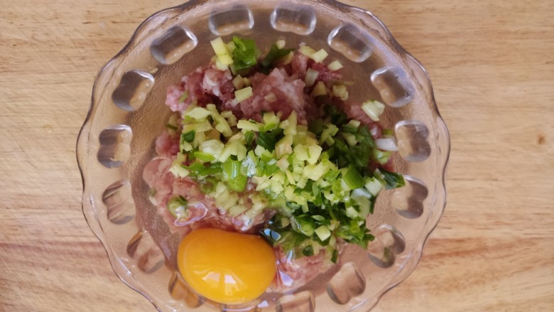 炸藕盒,把猪肉馅儿和，葱姜碎放在一起，打入一个鸡蛋。