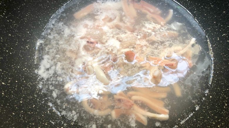 海鲜炒线面,锅里放入一碗水烧开，把鱿鱼放入焯熟，捞起来待用