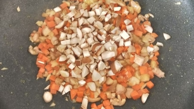 胡萝卜香菇炒鸡丁,接着倒入香菇丁，翻炒均匀。