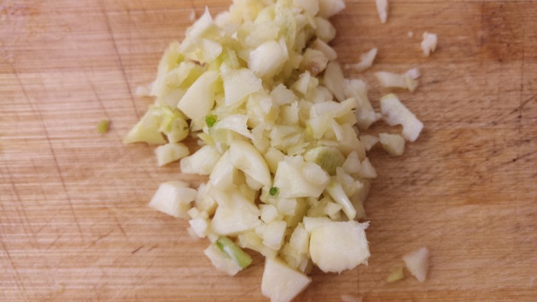 花生米拌黄瓜,接着把蒜切成蒜末。