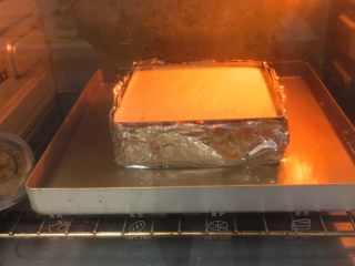 轻芝士蛋糕,烤箱事先预热，金盘中注入热水，烤箱温度150度，模具坐入水中。