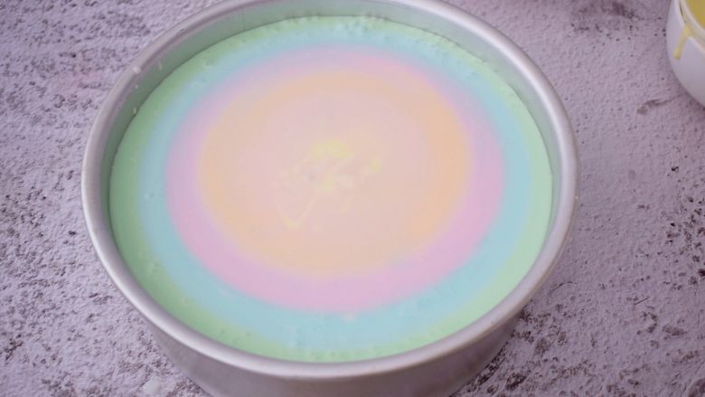 彩虹慕斯蛋糕（八寸）,再把第二份彩色慕期从中间倒入，让它自然扩期，依次这次直至最后的彩色慕期糊倒完，放入冰箱冷藏4-6小时定型