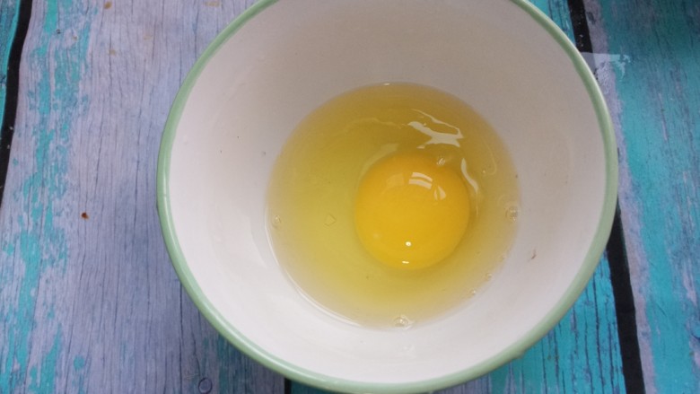 炒鸡蛋,把鸡蛋打入碗中。