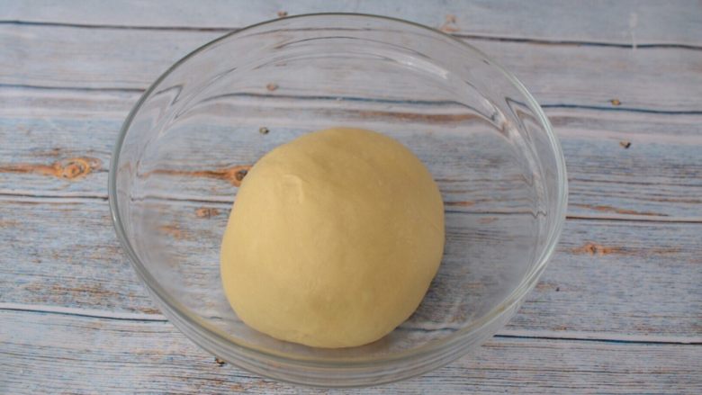 卡达仕面包,取出面团揉圆盖上保鲜膜放在温暖处发酵至两倍大左右