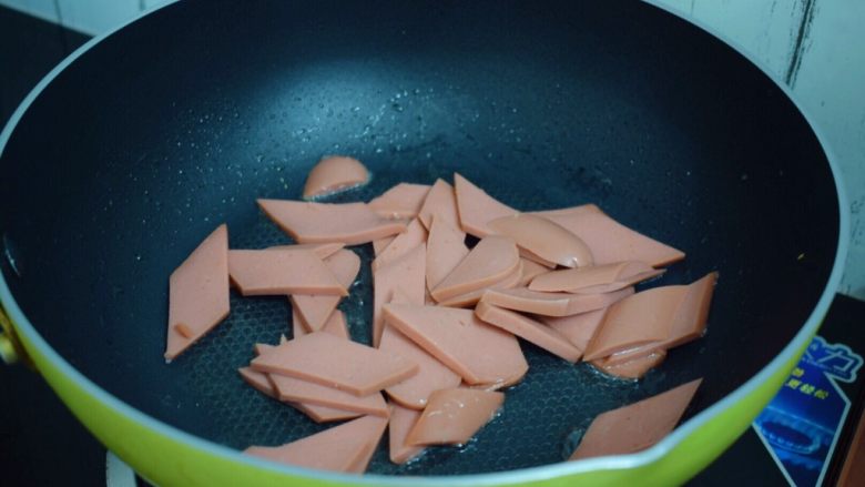 鸡蛋炒火腿肠,原锅倒入适量的食用油烧热后放入火腿肠翻炒至变色