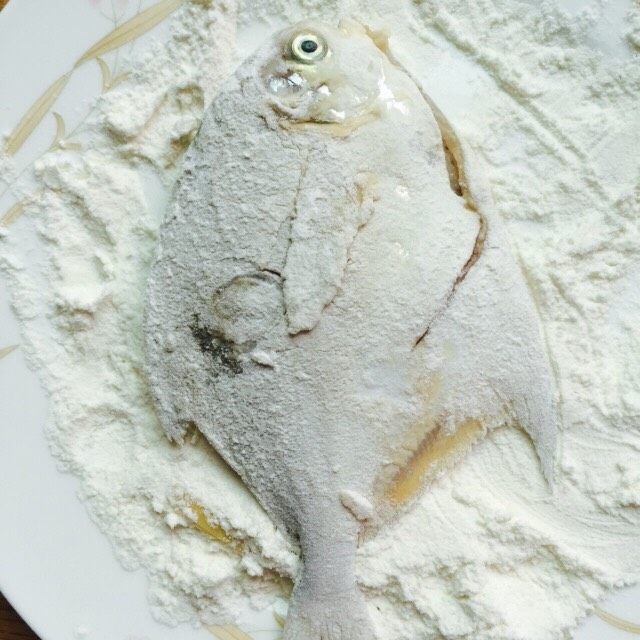 香煎椒盐小鲳鱼,腌制后的鲳鱼用厨房纸擦干水分，取一盘子添加两勺面粉均匀的涂抹鱼身