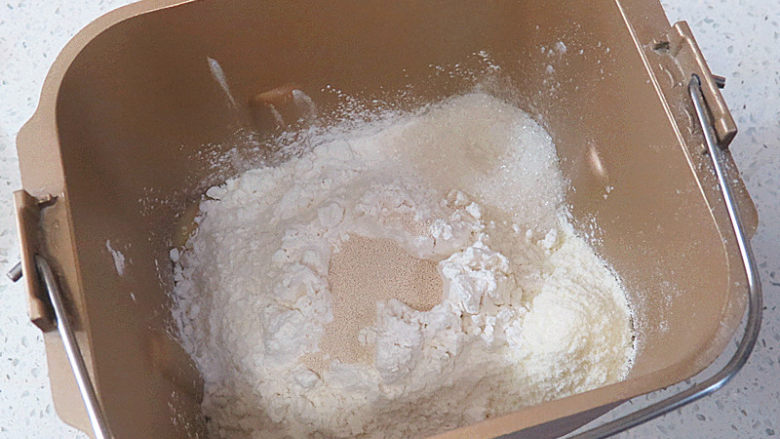 粉粉少女心【火龙果椰蓉心形面包】,把果泥汁倒入面包机桶里，继续放入鸡蛋液、盐、糖、奶粉、高筋面粉，最后放入干酵母。开启和面程序20分钟