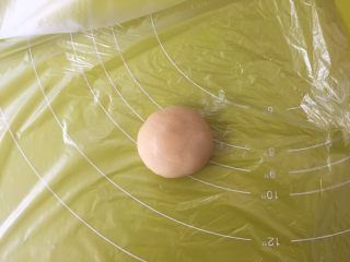 双蛋黄莲蓉月饼,冰箱取出冷藏的月饼皮材料，取25克一份面团，用手掌搓圆放在保鲜袋上；
