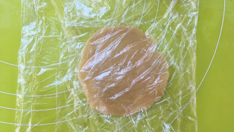 爱心金沙月饼,取15克松弛好的面团搓圆，上下盖保鲜膜，用擀面杖擀圆；
