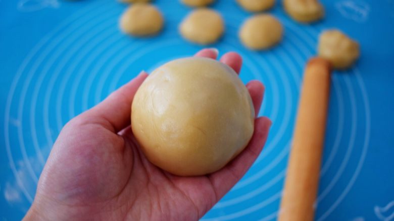 紫薯蛋黄月饼,利用虎口慢慢往上推，收紧收口再揉成光滑的圆球状