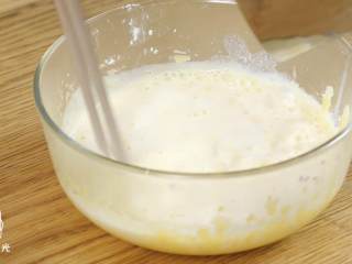 奶黄包18m+,往蛋黄糊中倒牛奶，不断搅拌。